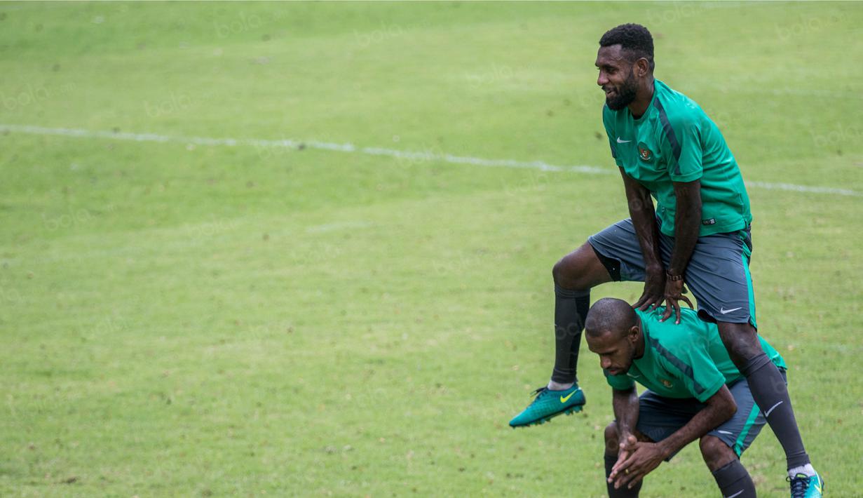 Bek Timnas Indonesia, Yanto Basna, terlihat canggung saat harus melompati seniornya Boaz Solossa saat dirinya berlatih di Lapangan SPH Karawaci, Banten, Minggu (11/12/2106). (Bola.com/Vitalis Yogi Trisna)