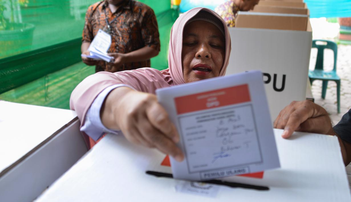 Warga memasukan surat suara yang telah dicoblos pada pemungutan suara ulang pemilu 2019 di TPS-6 Desa Lamteumen Timur, Banda Aceh, Aceh, Kamis (25/4). Pemungutan suara ulang karena adanya penggunaan formulir C6 pemilih yang telah meninggal pada pemilu 17 April lalu. (CHAIDEER MAHYUDDIN/AFP)