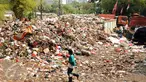 Warga melintas di dekat tumpukan sampah yang ada di Tempat Pembuangan Sampah Sementara Kalibata, Jakarta, Rabu (4/11/2015). Penumpukan sampah terkait aksi pemblokadean jalan menuju TPST Bantar Gebang. (Liputan6.com/Helmi Fithriansyah)