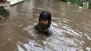 Seorang anak bermain air saat banjir menggenangi kawasan Cilandak Timur, Jakarta Selatan, Selasa (22/1). Hujan deras yang mengguyur Jakarta dan sekitarnya sejak pagi menyebabkan banjir di sejumlah sudut Ibu Kota. (Liputan6.com/Immanuel Antonius)