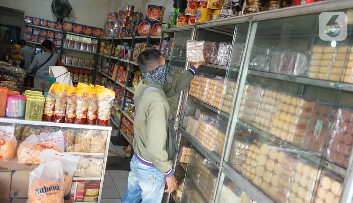 Pembeli melihat dagangan kue kering di salah satu toko penjualan kue kering di kawasan Ciracas, Jakarta, Selasa (19/5/2020). Adanya pandemi covid-19 diakui para pedagang menyebabkan penjualan kue kering menjelang lebaran turun hingga 50 persen. (Liputan6.com/Immanuel Antonius)