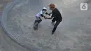 Instruktur melatih seorang anak menggunakan skateboard dengan memakai masker dan face shield di Crooz Shophouse di kawasan Duren Tiga, Jakarta Selatan, Minggu (2/8/2020). Mereka kembali melakukan latihan seminggu dua kali dengan menerapkan protokol kesehatan. (merdeka.com/Arie Basuki)
