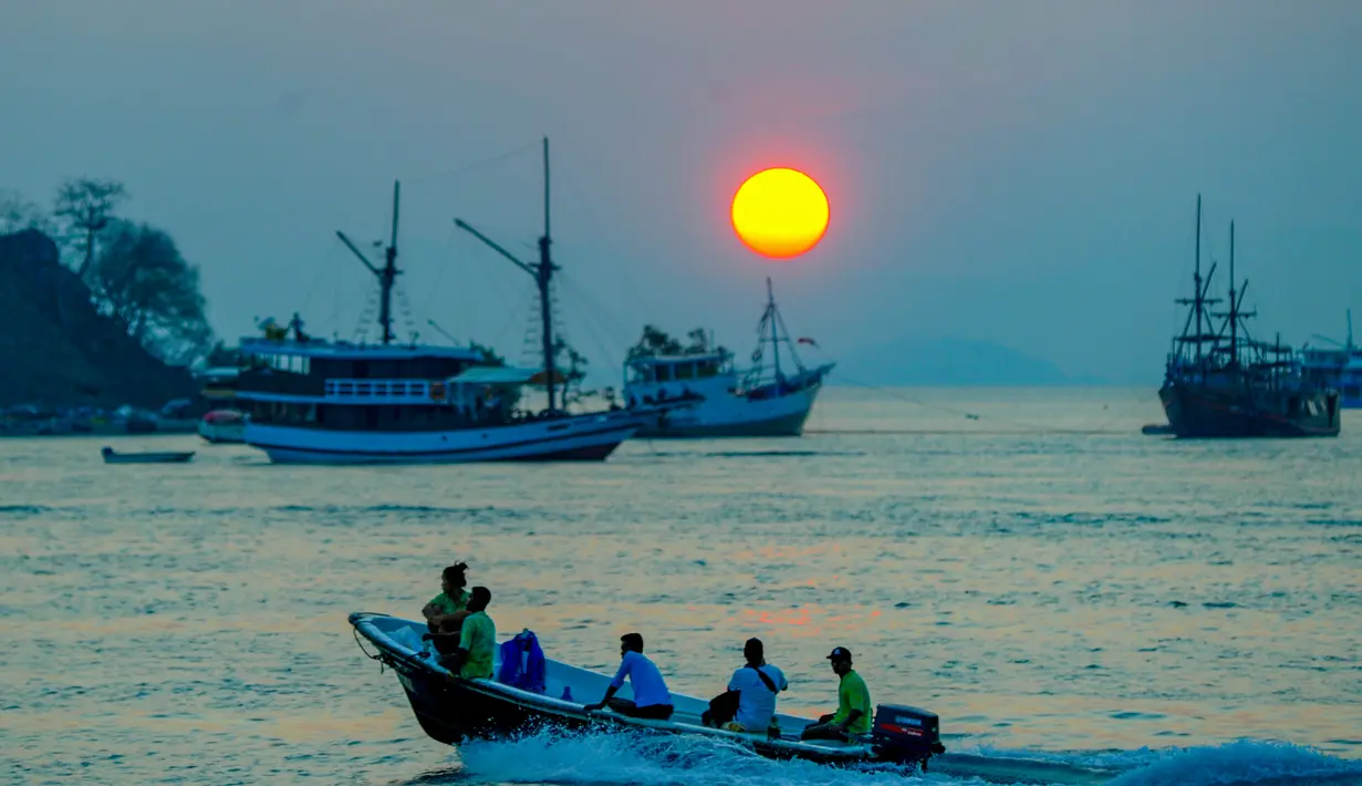 Hotel, pantai, hingga bukit menjadi spot favorit wisatawan yang datang khusus untuk menikmati momen emas tersebut. Tampak dalam foto, Sebuah perahu melintas di perairan Labuan Bajo, Flores, Nusa Tenggara Timur sesaat sebelum matahari terbenam. (merdeka.com/Arie Basuki)