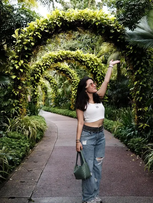 Marsha Aruan memadukan cropped top tanpa lengan berwarna putih dengan celana panjang jeans, serta menenteng tas tangan hijau. [Foto: Instagram/aruanmarsha]