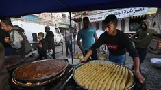 Penjual Palestina menyiapkan manisan di kios mereka di pasar menjelang buka puasa selama bulan suci Ramadhan di kota Rafah, Jalur Gaza selatan, pada 10 April 2022. (SAID KHATIB / AFP)