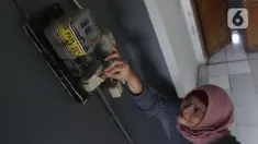 Warga memeriksa meteran listrik di kawasan Matraman, Jakarta, Kamis (2/4/2020). Di tengah pandemi COVID-19, pemerintah menggratiskan biaya tarif listrik bagi konsumen 450 Volt Ampere (VA) dan pemberian keringanan tagihan 50 persen kepada konsumen bersubsidi 900 VA. (Liputan6.com/Herman Zakharia)