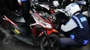  Petugas mencopot pentil motor saat melakukan razia parkir liar di kawasan Tanah Abang, Jakarta, Rabu (3/6/2015). Meski sudah disosialisasikan, kenyataannya masih banyak orang yang tak menghiraukan peraturan tersebut. (Liputan6.com/Johan Tallo)