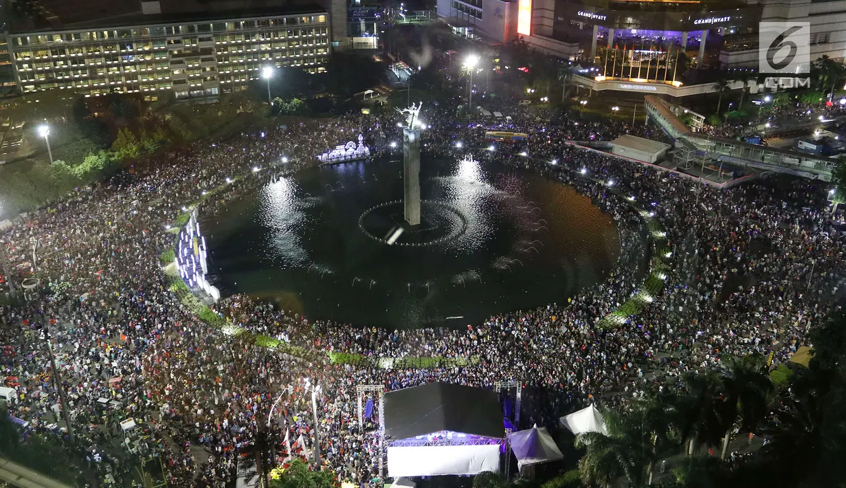 Ribuan warga memadati kawasan Bundaran HI pada malam pergantian tahun baru di Jakarta, Senin (1/1/2018). Bundaran HI menjadi salah satu pusat ibukota Jakarta untuk manyaksikan malam pergantian tahun. (Liputan6.com/Angga Yuniar)