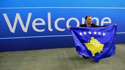 Seorang delegasi sepak bola Kosovo berfoto dekat tulisan selamat datang  saat merayakan diterimnya Kosovo sebagai anggota UEFA pada kongres UEFA ke-40 tahun di Hungexpo Fair Center, Budapest, Hungary, (3/52016). (AFP/Attila Kisbenedek)
