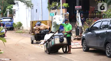 Pengumpul barang bekas mencari barang rusak akibat banjir di Ciledug Indah, Tangerang, Banten, Senin (21/2./2021). Pasca banjir melanda perumahan tersebut menjadi berkah bagi para pengumpul barang rongsok karena banyak barang yang di buang pemilik rumah. (Liputan6.com/Angga Yuniar)