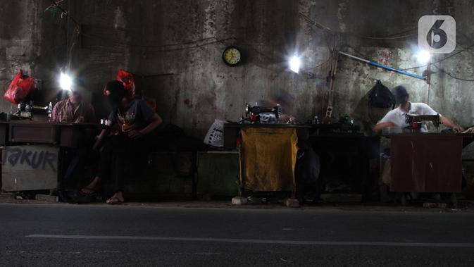 Penjahit vermak pakaian menyelesaikan pekerjaannya di kawasan Jatinegara, Jakarta, Selasa (29/9/2020). Pandemi Covid-19 berdampak pada sepinya pelanggan yang menjahitkan pakaian seperti biasanya. (merdeka.com/Imam Buhori)