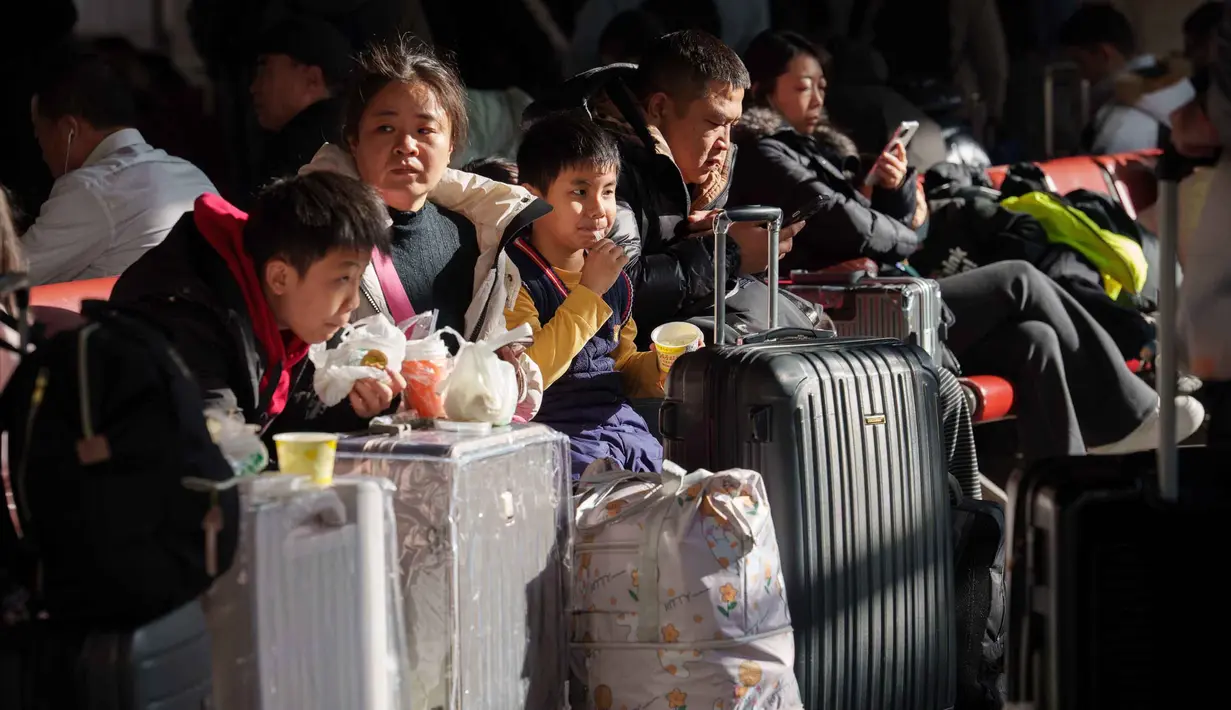 Otoritas transportasi China memprediksi, ada sekitar 9,5 miliar perjalanan penumpang akan dilakukan selama periode arus mudik yang akan berakhir pada 13 Maret 2026. Tampak dalam foto, para penumpang duduk di samping barang bawaan mereka sambil menunggu di stasiun kereta api dalam perjalanan pulang selama liburan Tahun Baru Imlek di Beijing, China, Selasa 10 Februari 2026. (AP Photo/Vincent Thian)