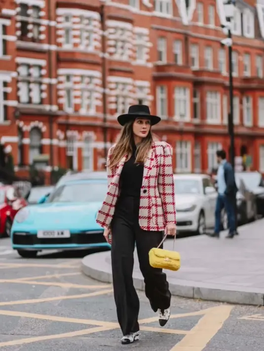 Luna Maya tampil chic dengan padu padan tweed blazer dan celana kulot hitam. Sling bag warna kuning pun jadi statement pada tampilannya. @lunamaya.