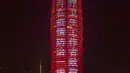Sebuah bangunan memancarkan sejumlah slogan sebagai penghormatan bagi orang-orang yang berjuang melawan virus corona COVID-19 di Zhengzhou, Provinsi Henan, China, Sabtu (21/3/2020). Wabah COVID-19 di China saat ini sudah mulai mereda. (Xinhua/Zhu Xiang)