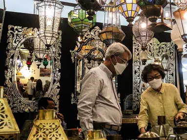 Pengunjung mengamati produk yang dipamerkan pada pameran International Handicraft Trade Fair (INACRAFT) di Jakarta Convention Center (JCC), Senayan, Jakarta, Kamis (24/3/2022). Setelah vakum selama dua tahun lamanya, Jakarta INACRAFT akhirnya akan kembali digelar. (Liputan6.com/Johan Tallo)