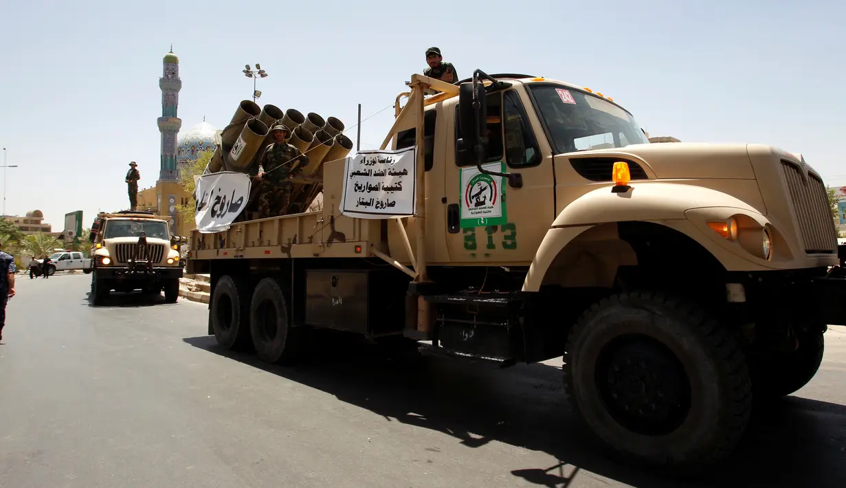 Pasukan keamanan Irak dan kendaraan tempurnya saat parade militer di Kota Baghdad, Irak, Selasa (12/7). Mulai dari tank, roket, meriam hingga peralatan tempur unggulan lainnya dipamerkan selama parade militer tersebut. (REUTERS/Khalid al Mousily)