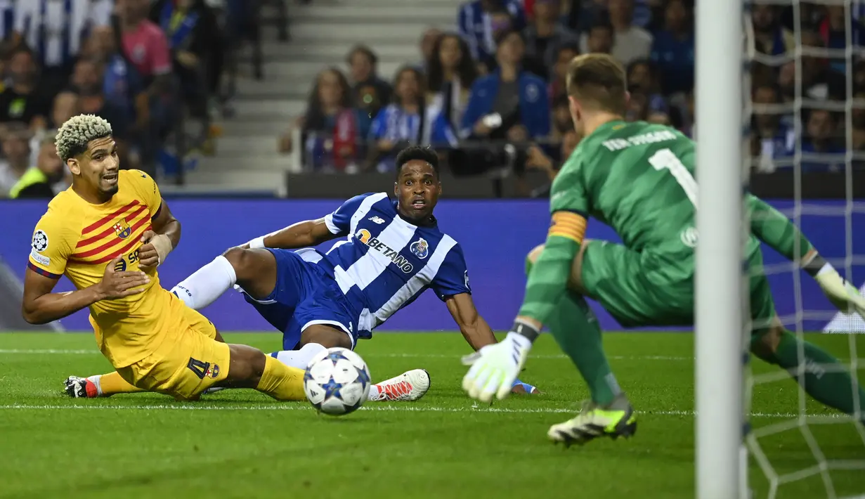 Bek Barcelona #04 Ronald Araujo bersaing dengan bek FC Porto #18 Wendell pada laga matchday 2 Liga Champions 2023/2024 yang digelar di Estadio do Dragao, Kamis (5/10/2023) dini hari WIB. (MIGUEL RIOPA / AFP)