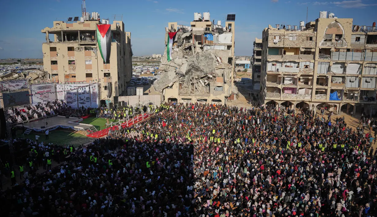 Warga berebut untuk bisa menyaksikan pernikahan tersebut, bahkan sampai memanjat reruntuhan bangunan, untuk menyaksikan upacara tersebut. Tampak dalam foto, warga Palestina menyaksikan dan merayakan upacara pernikahan massal di Kota Hamad, Khan Younis, Jalur Gaza, Selasa 2 Desember 2025. (AP Photo/Abdel Kareem Hana)