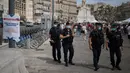 Polisi anti huru-hara Prancis mengamati warga yang mengenakan masker di Marseille, Selasa (18/8/2020). Pemerintah Prancis mengirim polisi anti huru hara ke wilayah Marseille untuk membantu menegakkan peraturan penggunaan masker saat negara itu mencatat lonjakan kasus COVID-19. (AP Photo/Daniel Cole)