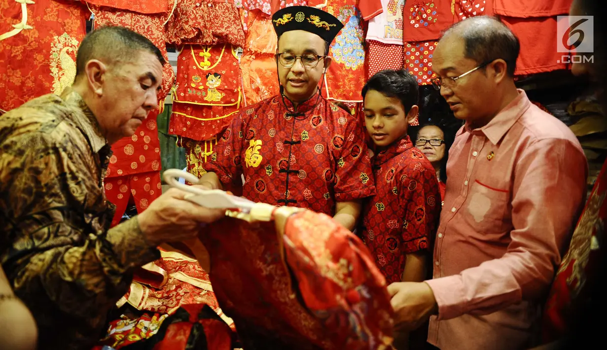 Gubernur DKI, Anies Baswedan dan anaknya, Kaisar memilih baju tradisional khas China di sekitar Vihara Dharma Bakti, Jakarta Barat, Jumat (16/2). Anies mendatangi Vihara Dharma Bakti dalam rangka menyemarakkan Imlek 2018. (Liputan6.com/Gempur M Surya)