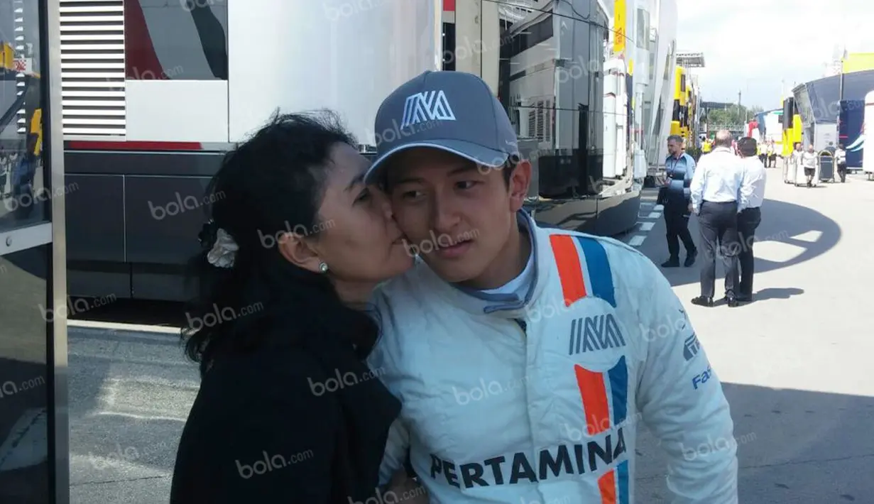 Pebalap Manor Racing asal Indonesia, Rio Haryanto, disambut ciuman sang bunda, Indah Pennywati, setelah balapan F1 GP Spanyol di Sirkuit Catalunya, Spanyol, Minggu (15/5/2016). (Bola.com/Reza Khomaini)