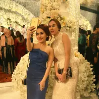 Resepsi pernikahan Nabila Syakieb dan Reshwara Argya Radinal turut dihadiri oleh deretan selebriti tanah air. Seperti Aura Kasih yang datang bersama temannya, ia tampak cantik mengenakan gaun putih panjang. (Fathan Rangkuti/Bintang.com)