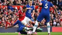 Pemain Chelsea, Trevoh Chalobah (kiri), berusaha menghentikan laju pemain Manchester United, Antony, dalam pertandingan partai tunda pekan ke-32 Liga Inggris 2022/2023 yang berlangsung di Old Trafford, Jumat (26/5/2023) dini hari WIB. (AFP/Oli Scarff)