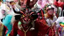 Orang-orang bersuka ria dalam balutan topeng setan selama festival  La Diablada di jalan-jalan kota Pillaro, Ekuador, Jumat (4/1). Anak-anak, pria, dan wanita memakai aneka pakaian menyeramkan menakut-nakuti orang-orang yang dilaluinya. (AP/Dolores Ochoa)