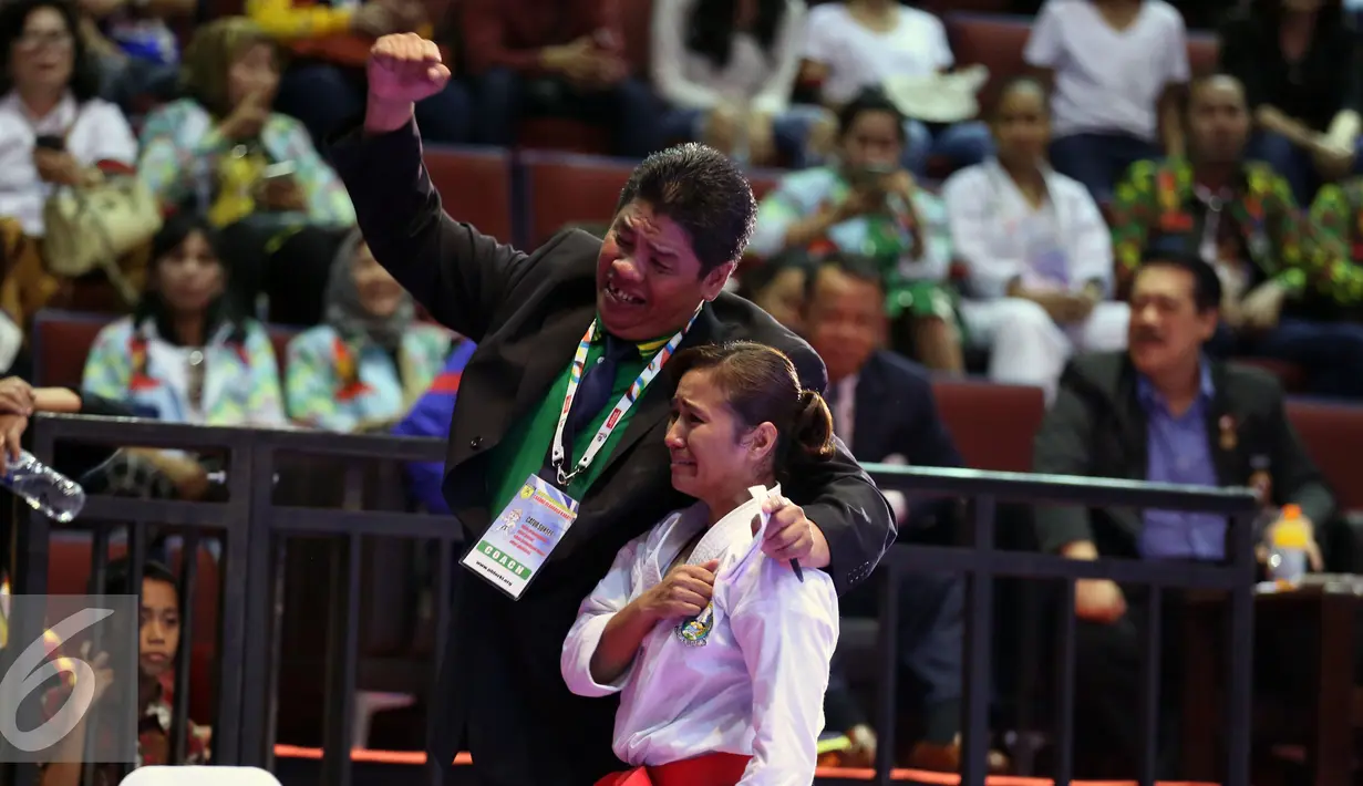 Karateka Jatim, Sisilia Agustiani bersama pelatihnya usai memenangi laga final Kata Putri PON XIX di GOR Sabuga, Bandung, Minggu (18/9). Di final, Sisilia berhasil meraih emas setelah unggul dari karateka Jabar, Yulianti. (Liputan6.com/Helmi Fithriansyah)