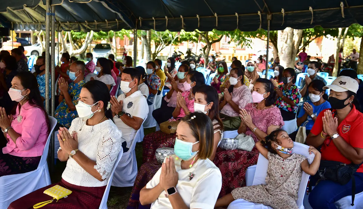 Umat Buddha menghadiri doa saat mereka merayakan Tahun Baru Buddha, yang secara lokal dikenal sebagai Songkran, di kuil Prachapirom di Narathiwat (12/4/2022). (AFP/Madaree Tohlala)