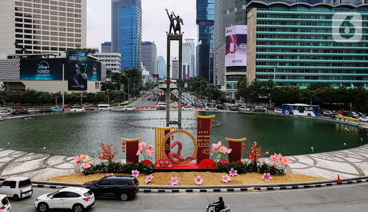Sejumlah pengendara kendaran bermotor melintasi dekorasi ornamen khas perayaan Imlek di Bundaran Hotel Indonesia, Jakarta, Senin (27/1/2025). (Liputan6.com/Angga Yuniar)