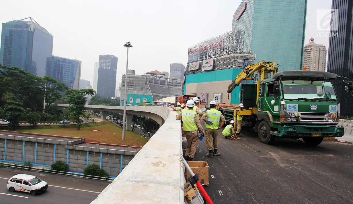 Pekerja mempersiapkan alat untuk melakukan uji beban statis dan dinamis Simpang Susun Semanggi, Jakarta, Kamis (13/7). Uji beban dilakukan guna menguji kelayakan Simpang Susun Semanggi sebelum diresmikan 17 Agustus mendatang. (Liputan6.com/Angga Yuniar)