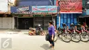Warga melintas di depan toko yang ada di Jalan Jatinegara Barat, Jakarta, Jumat (21/8/2015). Jalan Jatinegara Barat ditutup terkait proses penggusuran warga yang tinggal di sekitar bantaran Kali Ciliwung di Kampung Pulo. (Liputan6.com/Helmi Fithriansyah)