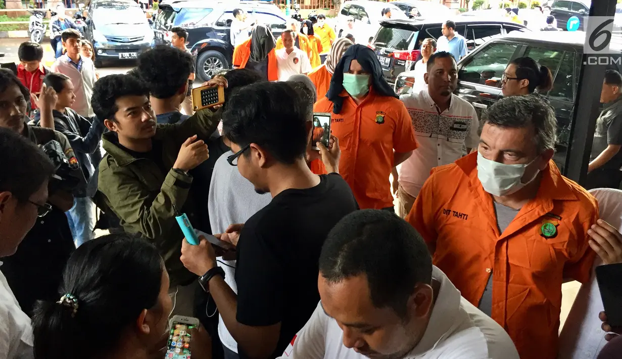 Sejumlah tersangka dihadirkan di Polda Metro Jaya, Jakarta, Senin (18/12). Pihak kepolisian juga menyita berupa puluhan kartu berbagai macam bank, uang ratusan juta rupiah, serta beberapa alat skimming. (Liputan6.com/Immanuel Antonius)