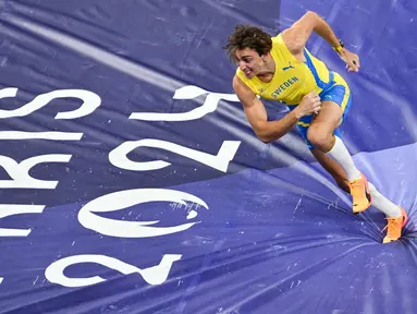 Armand Duplantis dari Swedia merayakan pencapaian rekor dunia baru 6,25 meter dalam final lompat galah putra cabang atletik di Olimpiade Paris 2024 di Stade de France, Saint-Denis, Paris, pada 5 Agustus 2024. (Andrej ISAKOVIC/AFP)