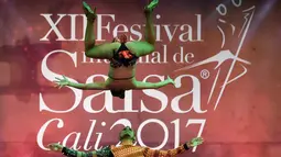 Penari salsa asal Kolombia Angie Adrada (atas) melakukan aksi akrobatik saat tampil dalam kategori Pasangan Cabaret di Festival Salsa Dunia XII, di Cali, Kolombia (1/10). (AFP Photo/Luis Robayo)