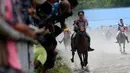Seorang joki memacu kudanya pada lomba pacuan kuda tradisional di Takengon, Aceh, 10 Maret 2018. Ragam aksi para joki selalu menjadi tontonan, dan masyarakat selalu menyambut dengan antusias. (AFP PHOTO/CHAIDEER MAHYUDDIN)