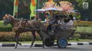 Pengunjung berkeliling naik delman hias di Monumen Nasional (Monas), Jakarta, Sabtu (15/6/2019). Sebelumnya delman hias tersebut dilarang kini beroperasi kembali, delman tersebut mengenakan tarif pada pengunjung bervariasi untuk berkeliling di luar IRTI Monas. (merdeka.com/Imam Buhori)