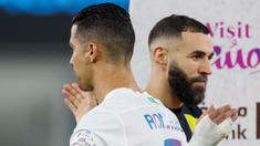 Pemain Al Nassr, Cristiano Ronaldo, berpapasan dengan pemain Al Ittihad, Karim Benzema, dalam laga tunda pekan ke-17 Liga Arab Saudi di King Abdullah Sport City Stadium, Jeddah, Rabu (27/12/2023). Al Nassr menang dengan skor 5-2. (Photo by AFP)