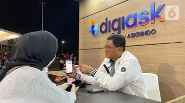 Direktur Utama Askrindo, Priyastomo melayani pengunjung saat transaksi pembelian Asuransi Kecelakaan Diri Askrindo pada aplikasi digiask di booth digiAsk Askrindo di gelaran Java Jazz Festival 2022, Jakarta (29/05/2022). Aplikasi digiAsk dari Askrindo memberikan proteksi asuransi kecelakaan diri untuk seluruh penonton, artis dan crew saat gelaran Java Jazz Festival 2022. (Liputan6.com/HO/Askrindo)