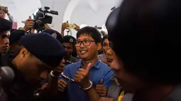 Wartawan Reuters Wa Lone dengan tangan di borgol tiba untuk menjalani sidang di Yangon (10/1). Menurut hakim, Wa Lone dan Kyaw Soe Oo akan dihukum selama 14 tahun jika terbukti bersalah. (AFP Photo/Ye Aung Thu)