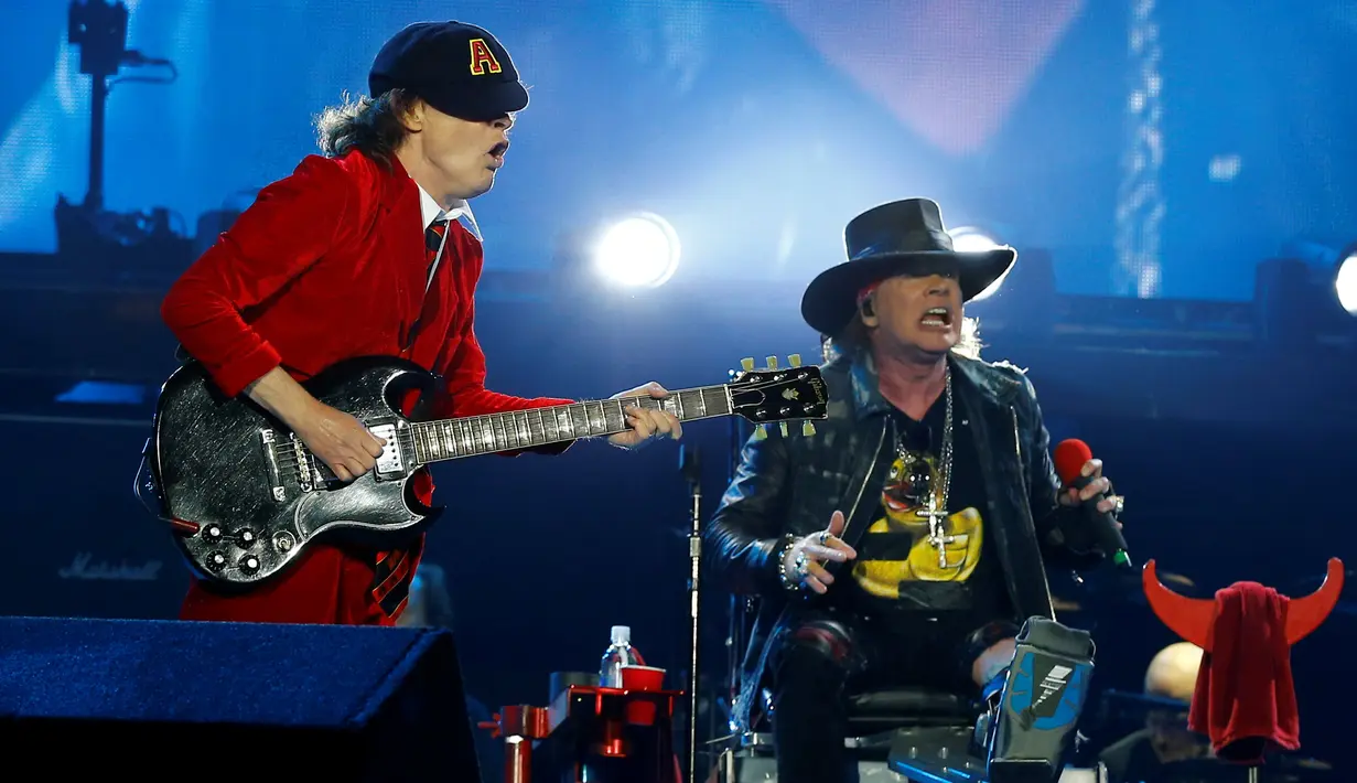 Gitaris Angus Young dan Vokalis baru band AC/DC, Axl Rose saat tampil dalam "Rock Or Bust World Tour" di tur konser dunia di Andalusia, Seville, Spanyol, (10/5). Axl ditunjuk untuk menggantikan sang vokalis AC/DC, Brian Johnson. (REUTERS/Marcelo del Pozo)