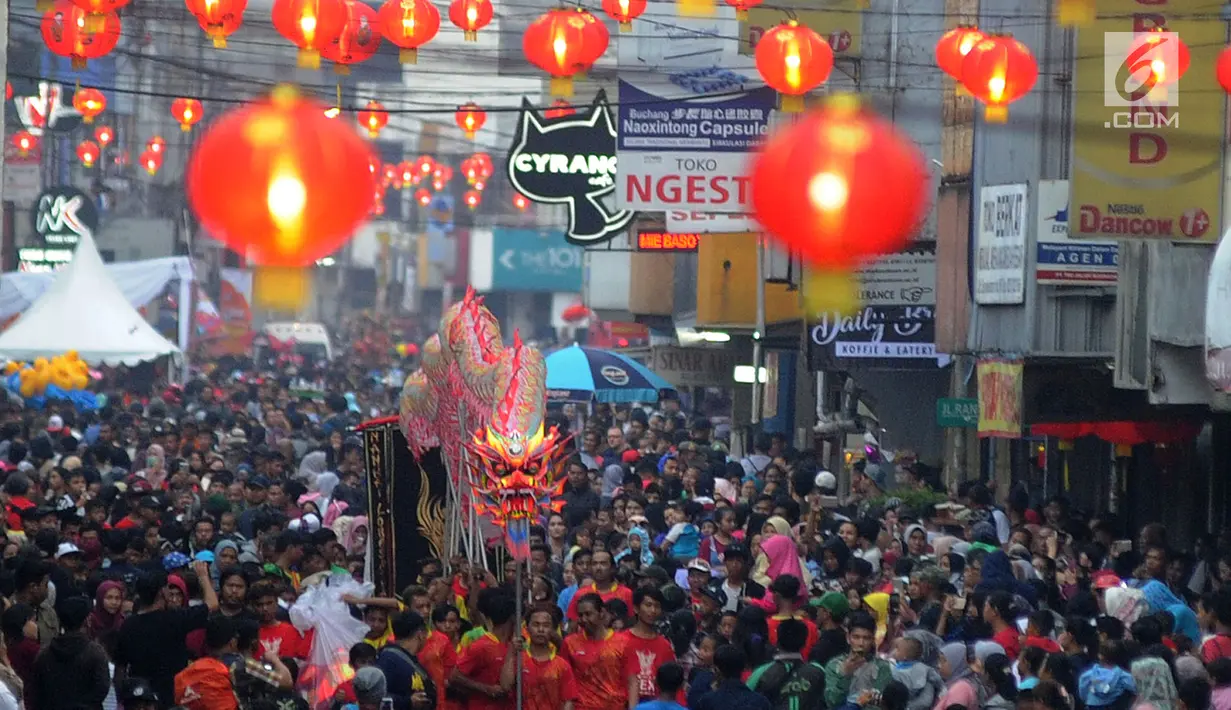 Warga memadati jalan raya saat arak-arakan atraksi liong perayaan Cap Go Meh melewati Jalan Suryakencana, Bogor, Jawa Barat, Selasa (19/2). Acara ini merupakan puncak perayaan Tahun Baru Imlek 2570. (Merdeka.com/Arie Basuki)