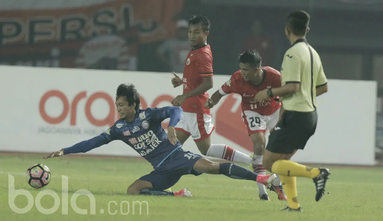 Pemain Arema, Arif Suyono, terjatuh saat berebut bola dengan pemain Persija, Sandi Suthe pada laga lanjutan liga 1 Indonesia di Stadion Patriot, Bekasi, Jumat (02/06/2017). Persija Menang 2-0. (Bola.com/M Iqbal Ichsan)
