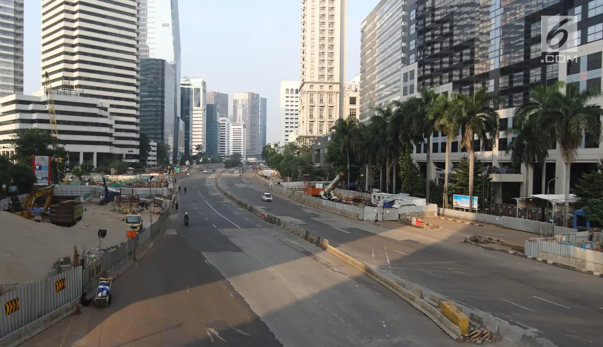 Suasana lengang di Jalan Sudirman, Jakarta, Minggu (17/6). Hari Bebas Kendaraan Bermotor (HBKB) atau Car Free Day (CFD) ditiadakan tanggal 10, 17, 24 Juni 2018. (Liputan6.com/Arya Manggala)