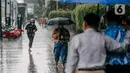 Pejalan kaki menggunakan payung saat hujan deras mengguyur kawasan Jalan Thamrin, Jakarta, Selasa (31/5/2022). Kecepatan angin maksimum mencapai 20 kt dan tekanan udara minimum 1005,8 mb.  (Liputan6.com/Faizal Fanani)
