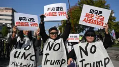 Para demonstran Korea Selatan yang mengenakan spanduk bertuliskan "Tolak Trump" memegang plakat selama demonstrasi yang mengecam tekanan Presiden AS Donald Trump untuk meningkatkan investasi Korea Selatan di AS, di Gyeongju pada 29 Oktober 2025, menjelang KTT Kerja Sama Ekonomi Asia-Pasifik (APEC). (Jung Yeon-je/AFP)