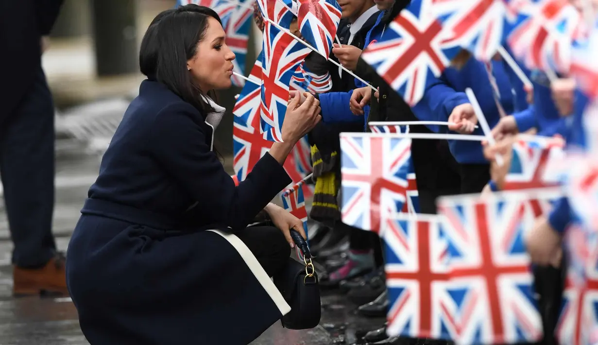 Meghan Markle menyapa anak-anak saat menghadiri sebuah acara yang diselenggarakan oleh perusahaan sosial Stemettes untuk merayakan Hari Perempuan Internasional di Millennium Point, Birmingham (8/3). (AFP Photo/Pool/Paul Ellis)