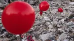 Balon yang tergantung di puing-puing bangunan yang runtuh di Antakya, Turki selatan, menyusul gempa berkekuatan 6,4 yang melanda pada 20 Februari, dua minggu setelah gempa berkekuatan 7,8 melanda dekat Gaziantep dan telah menewaskan lebih dari 44.000 orang. Di sisi jalan yang sibuk di Antakya, puluhan balon merah berkibar, bergelantungan di reruntuhan. (AFP/Sameer Al-Doumy)