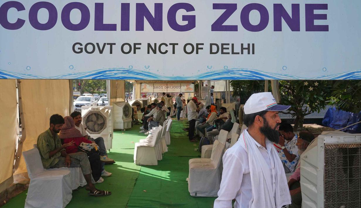 Para pengguna jalan beristirahat di stasiun pendingin pinggir jalan yang didirikan oleh pemerintah untuk memberikan kenyamanan bagi masyarakat dari teriknya musim panas di New Delhi, India, Rabu, 20 Mei 2026. (AP Photo/Manish Swarup)